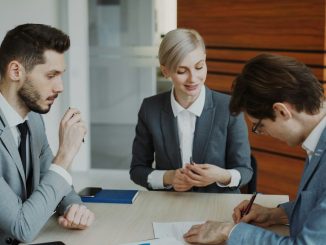 Business people signing a contract at a table